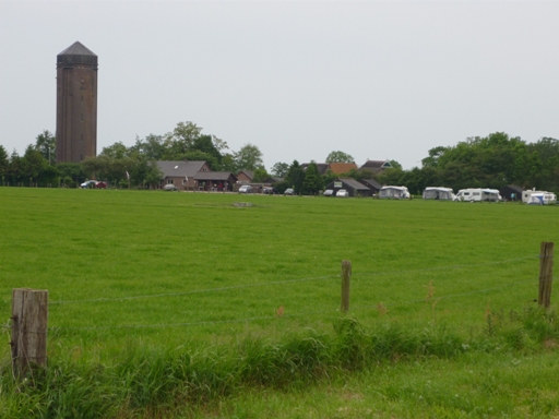 De camping gezien vanaf de wei, met de watertoren van Tuk erachter
